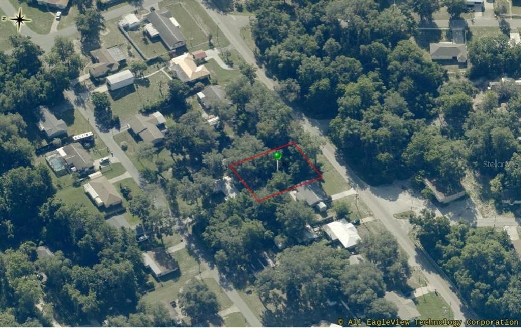 An aerial view shows a rectangular, tree-covered vacant lot outlined in red — 8731 E GOSPEL ISLAND ROAD, INVERNESS, FL