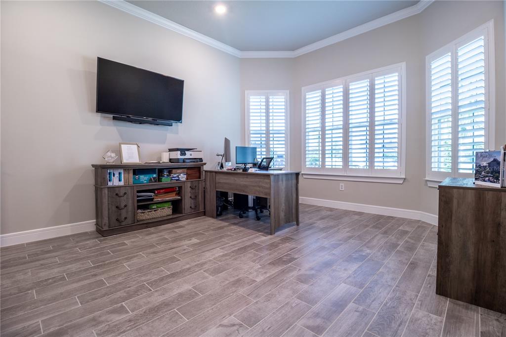 A home office features wood-look tile flooring, a desk, a media console, and plantation shutters — 3414 MICHIGAN STREET, LAKE MARY, FL
