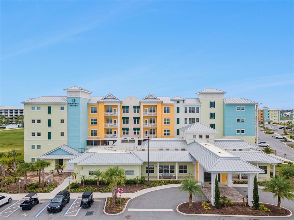 An exterior view of a multi-story Embassy Suites hotel building with a parking lot — 3151 SUNSET WALK DRIVE UNIT 1507, KISSIMMEE, FL