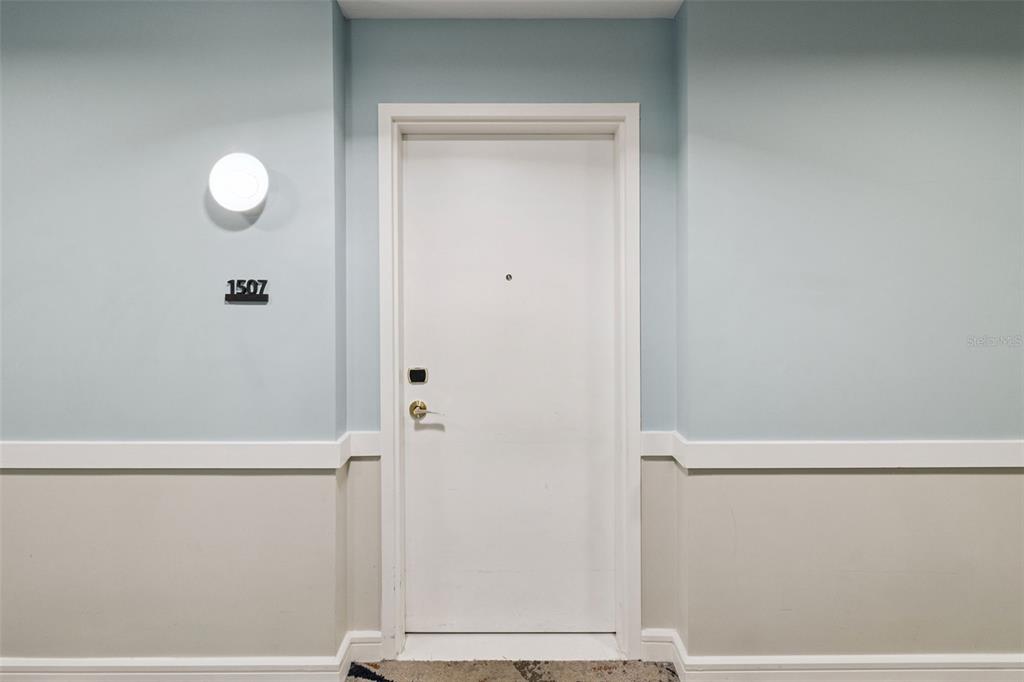 A white door with the number 1507 is centered on a light blue and beige wall — 3151 SUNSET WALK DRIVE UNIT 1507, KISSIMMEE, FL