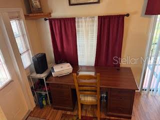 A home office features a wooden desk, a chair, and a printer in front of curtains — 9000 US HIGHWAY 192 UNIT 975, CLERMONT, FL