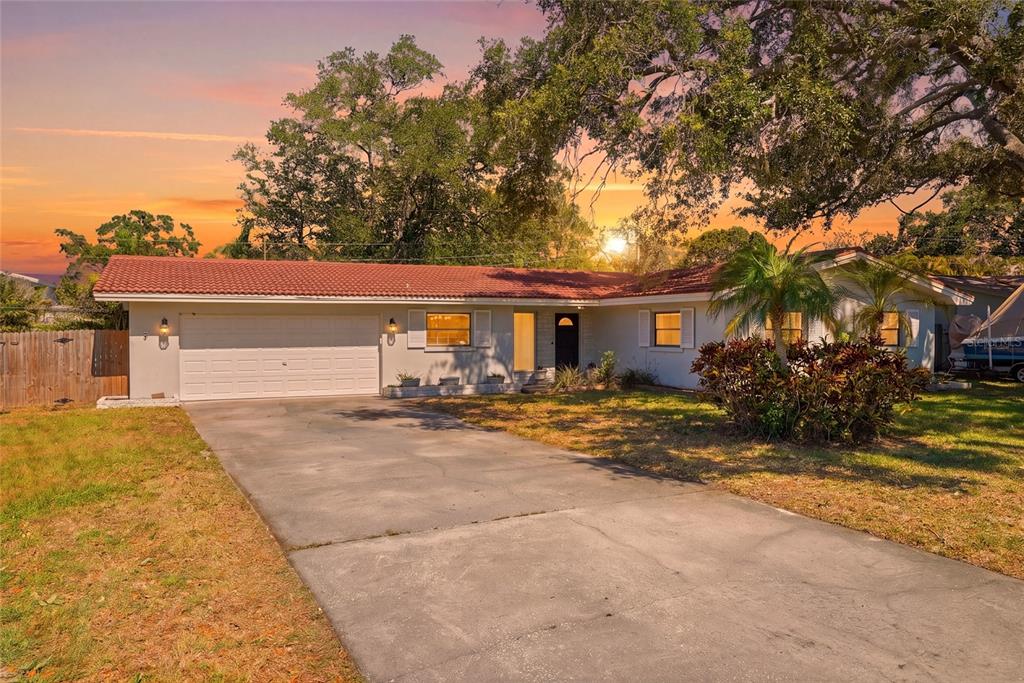 A single-story house with a red tile roof, white exterior, and a concrete driveway — 1349 VIEWTOP DRIVE, CLEARWATER, FL