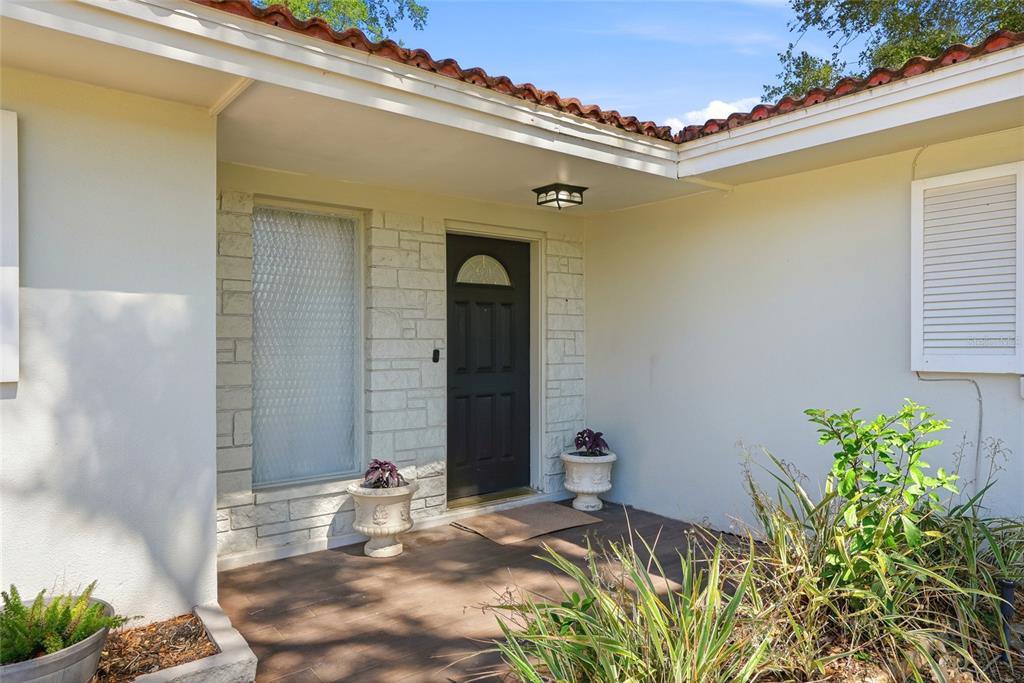 The exterior entrance features a dark front door, stone siding, and a tiled porch — 1349 VIEWTOP DRIVE, CLEARWATER, FL