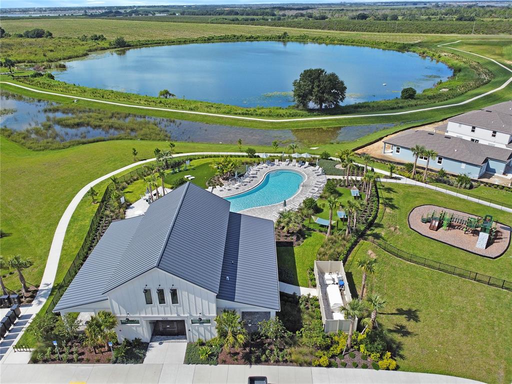 An aerial view shows a community clubhouse with a pool, playground, and adjacent lake — 437 WATERFORD DRIVE, LAKE ALFRED, FL