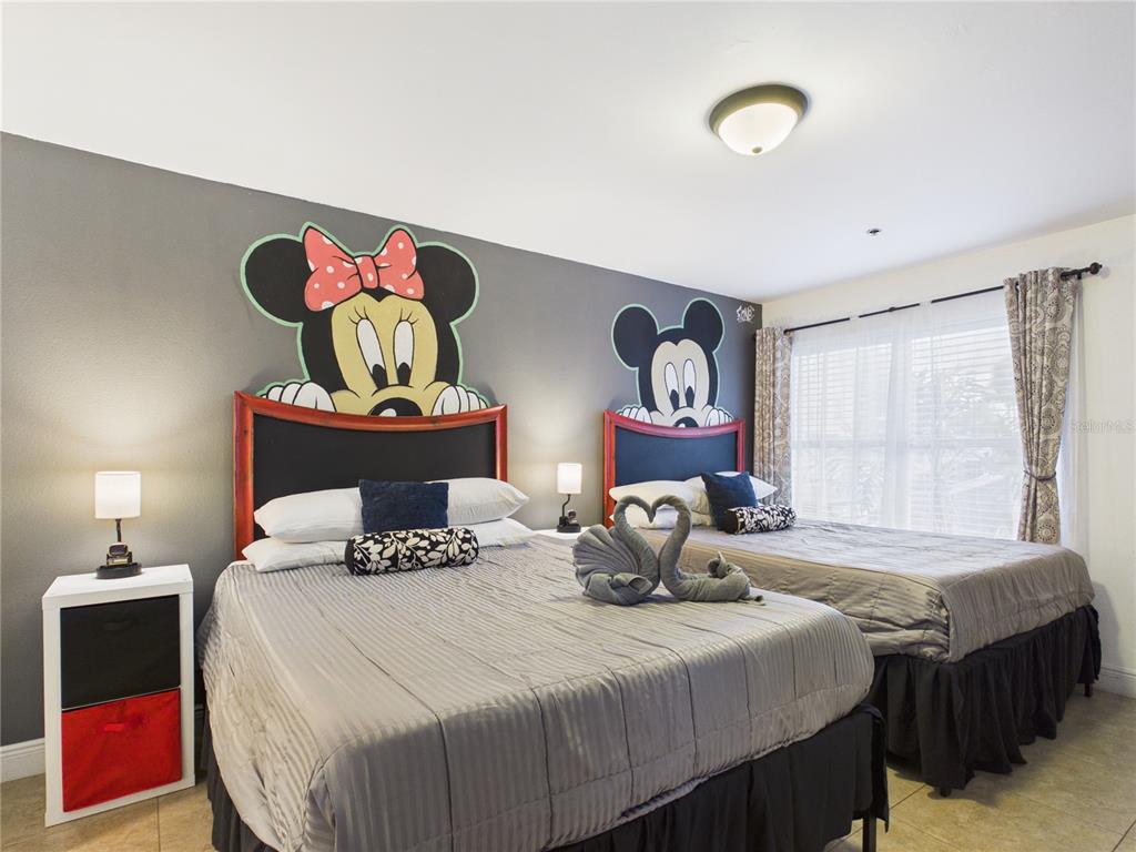 A bedroom features two beds with Mickey and Minnie Mouse headboard wall decals — 3100 PARKWAY BOULEVARD UNIT 728, KISSIMMEE, FL