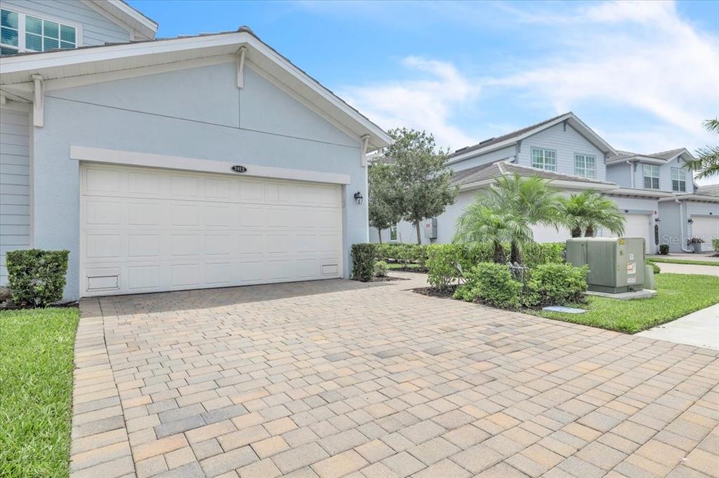 A light blue house with a white garage door and a paved driveway — 14120 POPPY FIELD LOOP UNIT 3812, PUNTA GORDA, FL