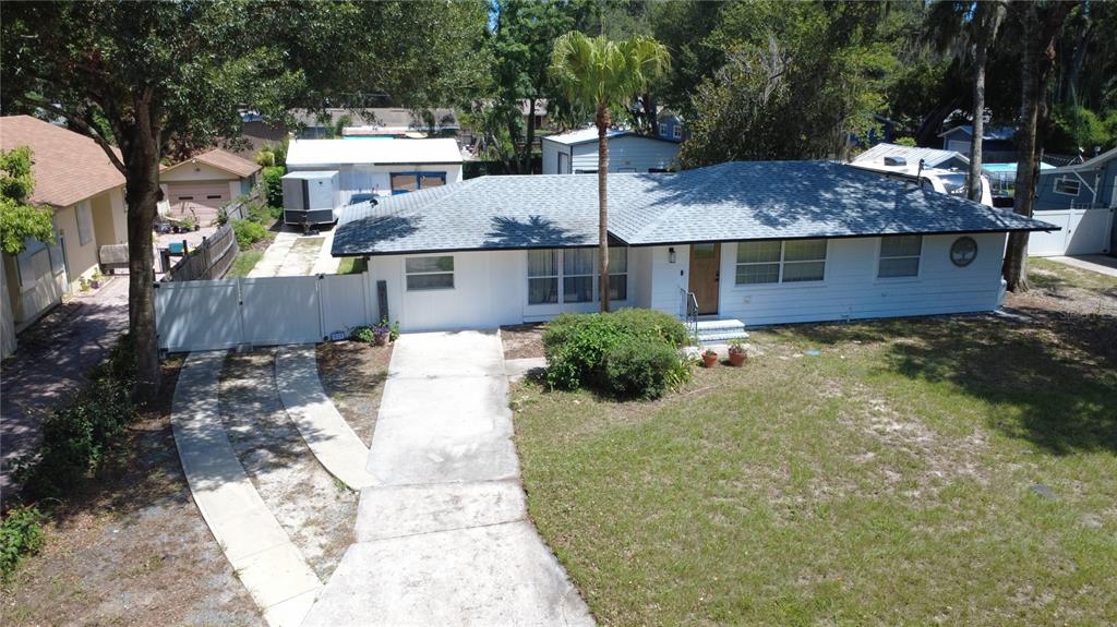 An aerial view of a white single-story house with a gray shingled roof and driveway — 925 E 10TH AVENUE, MOUNT DORA, FL