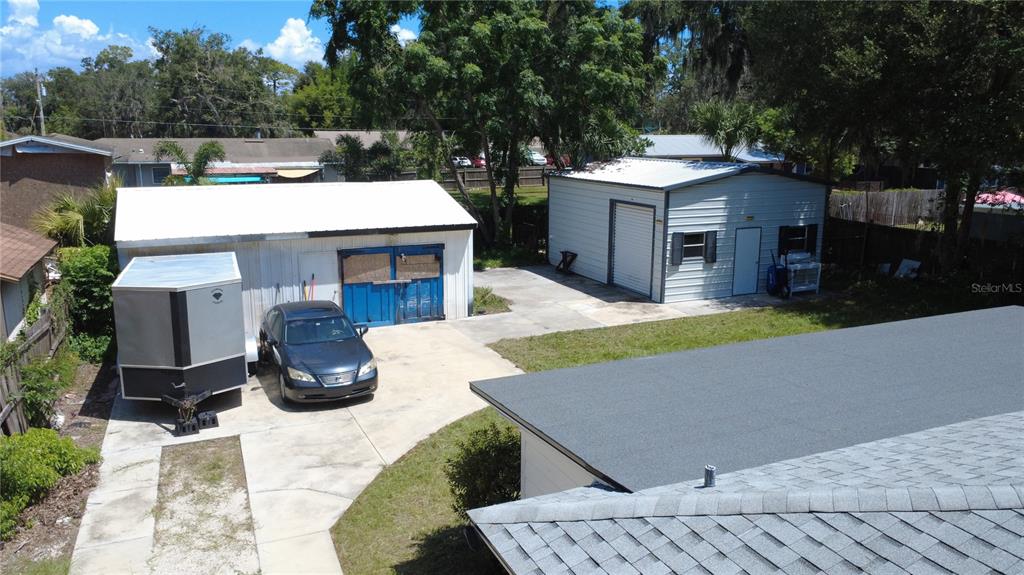An aerial view shows a backyard with two detached garages, a car, and a trailer — 925 E 10TH AVENUE, MOUNT DORA, FL