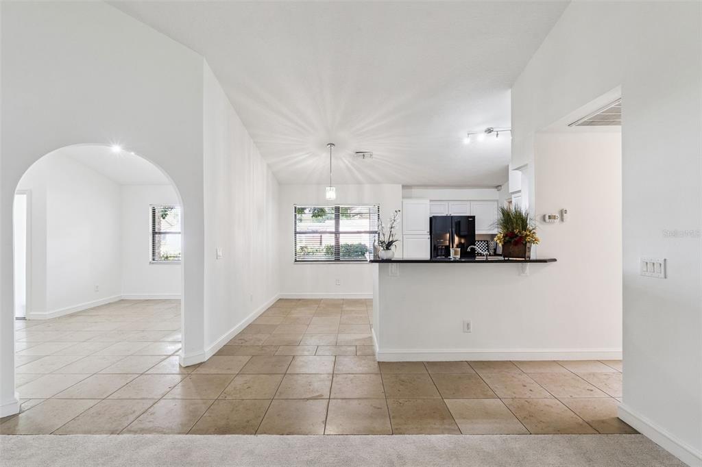 A kitchen with a breakfast bar, tile flooring, and an adjacent dining area — 9433 PALM TREE DRIVE, WINDERMERE, FL