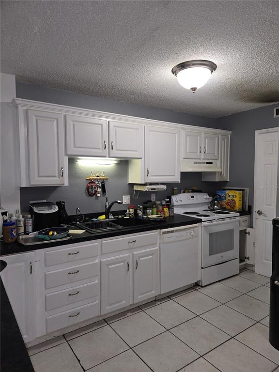 A multi-story apartment building sits behind a parking lot and a small pond — 6400 46TH AVENUE N UNIT 305, KENNETH CITY, FL