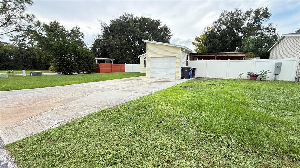 A concrete driveway leads to a detached garage with a single white door — 10404 BRUSSELS DRIVE, RIVERVIEW, FL