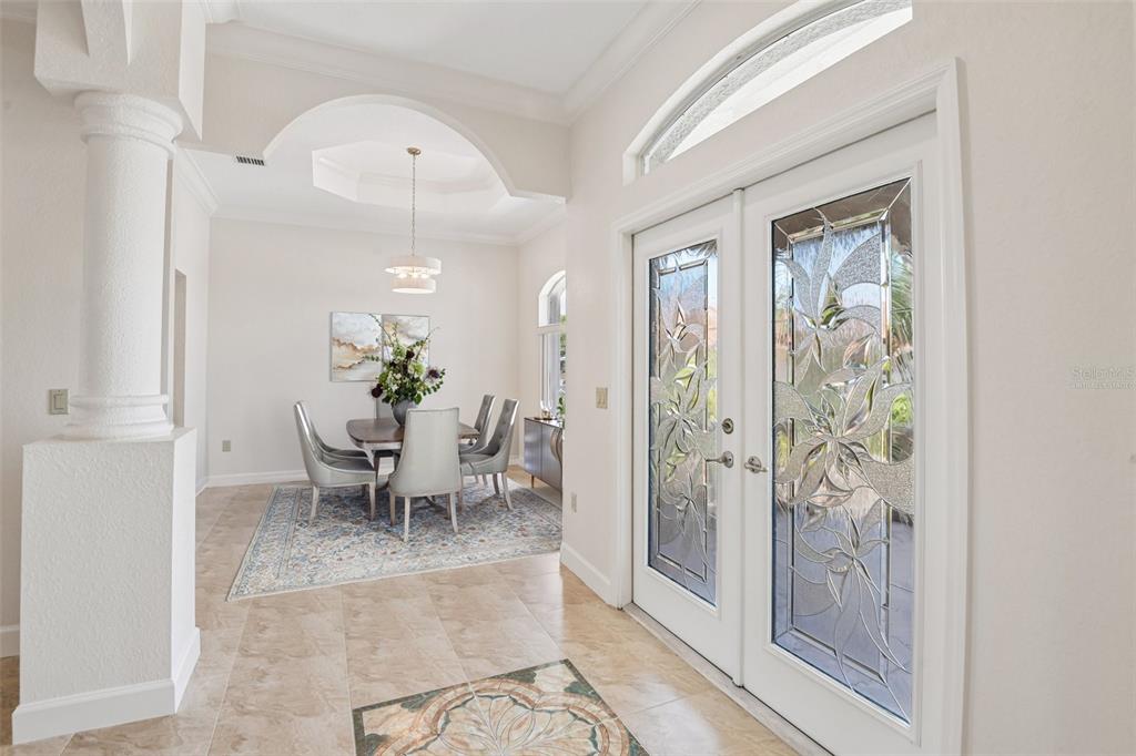 An entryway with tile floors leads to a dining room featuring a decorative arched ceiling — 8335 CHEYENNE DRIVE, SEMINOLE, FL