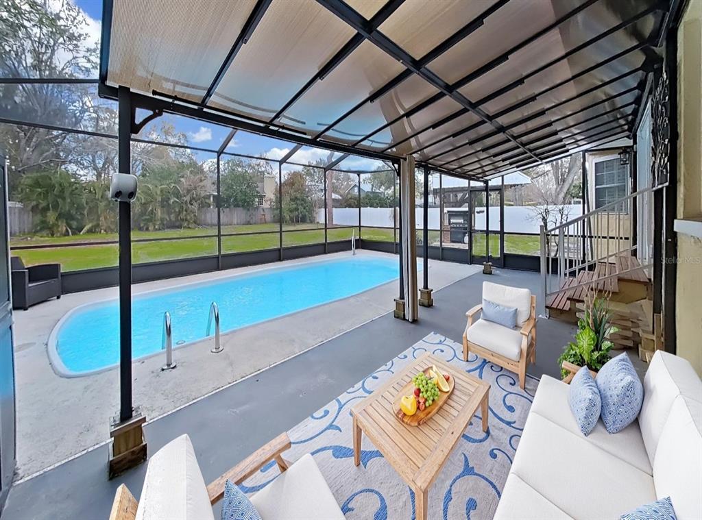 A covered patio with a swimming pool, outdoor seating, and a screen enclosure — 438 LAFAYETTE BOULEVARD, OLDSMAR, FL