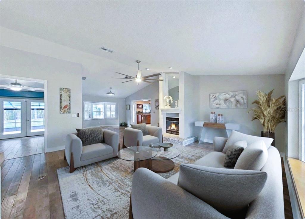 A living room features light gray furniture, a fireplace, and hardwood floors — 438 LAFAYETTE BOULEVARD, OLDSMAR, FL