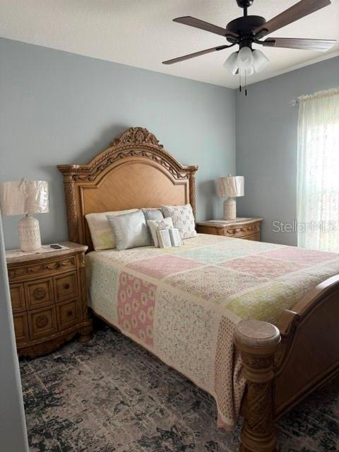 A bedroom features a wooden bed frame, a patterned quilt, and two matching bedside lamps — 9934 LENOX STREET, CLERMONT, FL