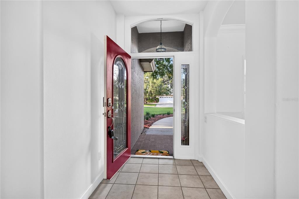 An entryway with a red front door, tile flooring, and a view of the outdoors — 19337 SPRING OAK DRIVE, EUSTIS, FL