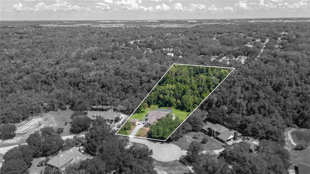A screened-in patio features a swimming pool with a spa and a paved deck — 6617 POLEY CREEK DRIVE W, LAKELAND, FL