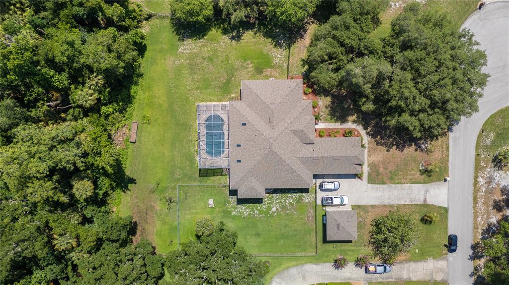A kitchen features white cabinetry, granite countertops, a center island, and stainless steel appliances — 6617 POLEY CREEK DRIVE W, LAKELAND, FL