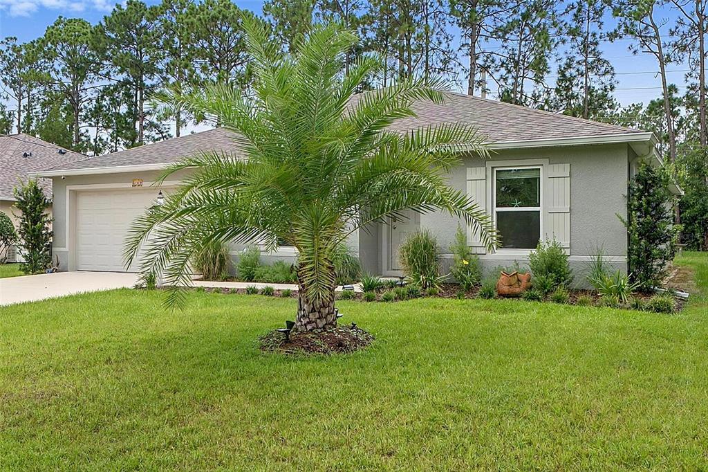 A single-story house with a palm tree in the front yard and a two-car garage — 177 UNDERWOOD TRAIL, PALM COAST, FL
