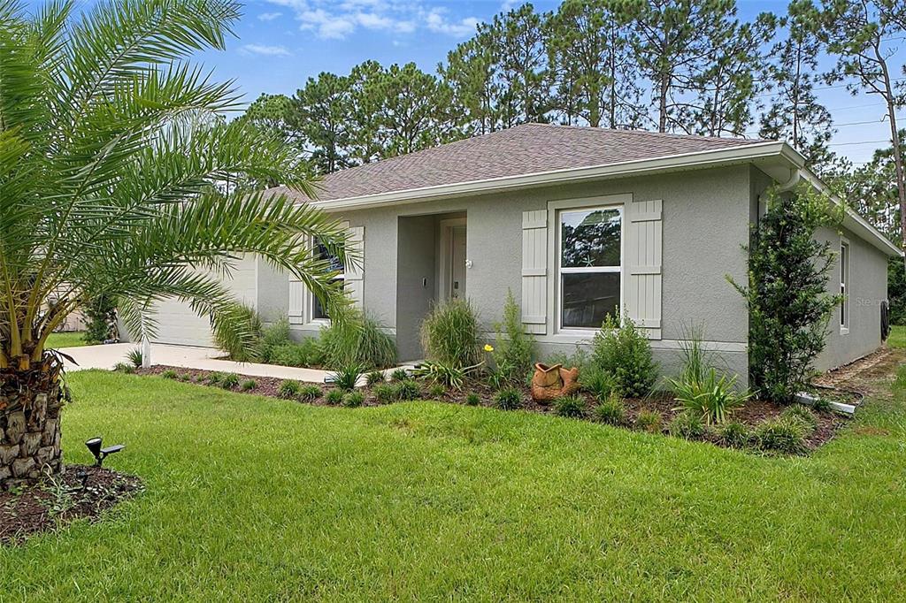 A single-story gray house with a palm tree, a front lawn, and a concrete driveway — 177 UNDERWOOD TRAIL, PALM COAST, FL
