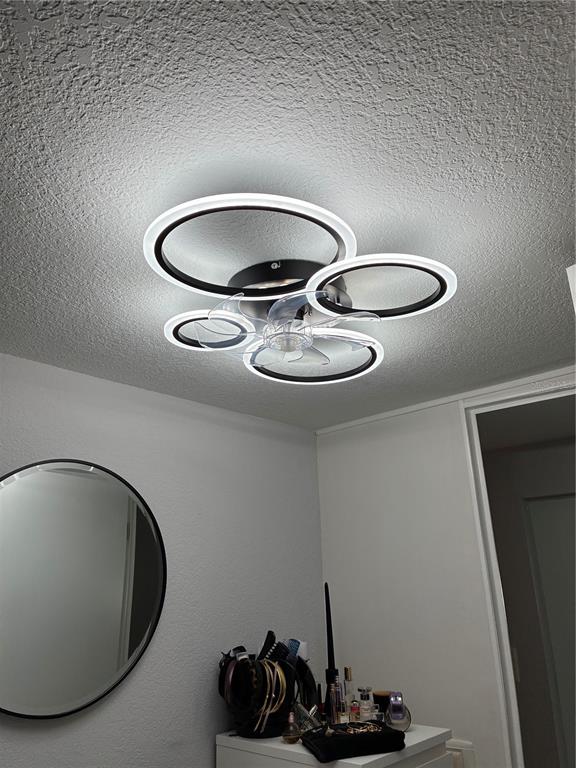 A modern circular LED ceiling light fixture with an integrated fan is mounted in a room — 30425 TIGER TAIL ROAD UNIT 346, SEBRING, FL