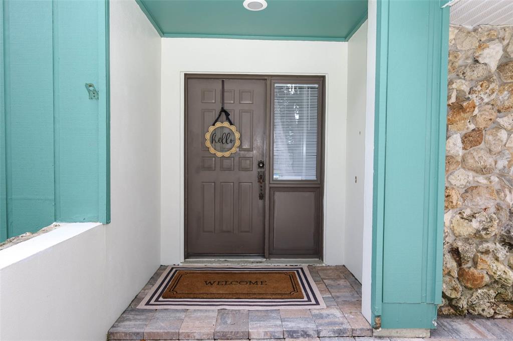 A front entryway features a brown door with a side light and a stone wall — 1015 ANTELOPE TRAIL, WINTER SPRINGS, FL