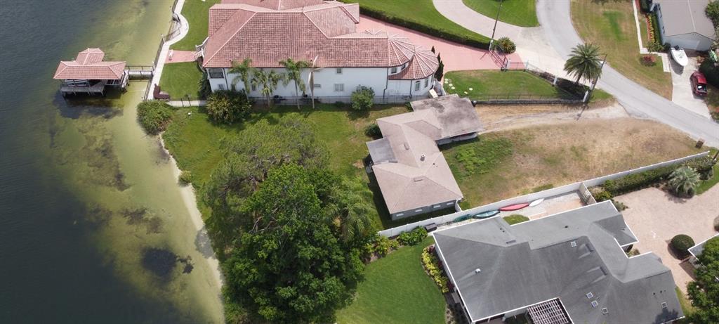 An aerial view shows three waterfront houses with lawns, a boat dock, and a driveway — 3045 CECELIA DRIVE, APOPKA, FL