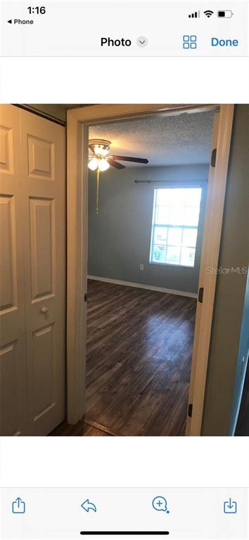 A view through a doorway into a bedroom with wood-look flooring and a ceiling fan — 215 LAKE BROOK CIRCLE UNIT 204, BRANDON, FL
