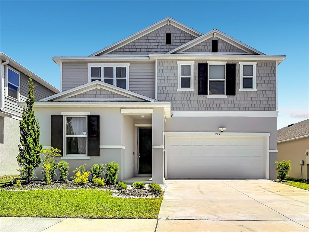 A two-story suburban house with a gray exterior, a two-car garage, and a front lawn — 795 OVERPOOL AVENUE, DAVENPORT, FL