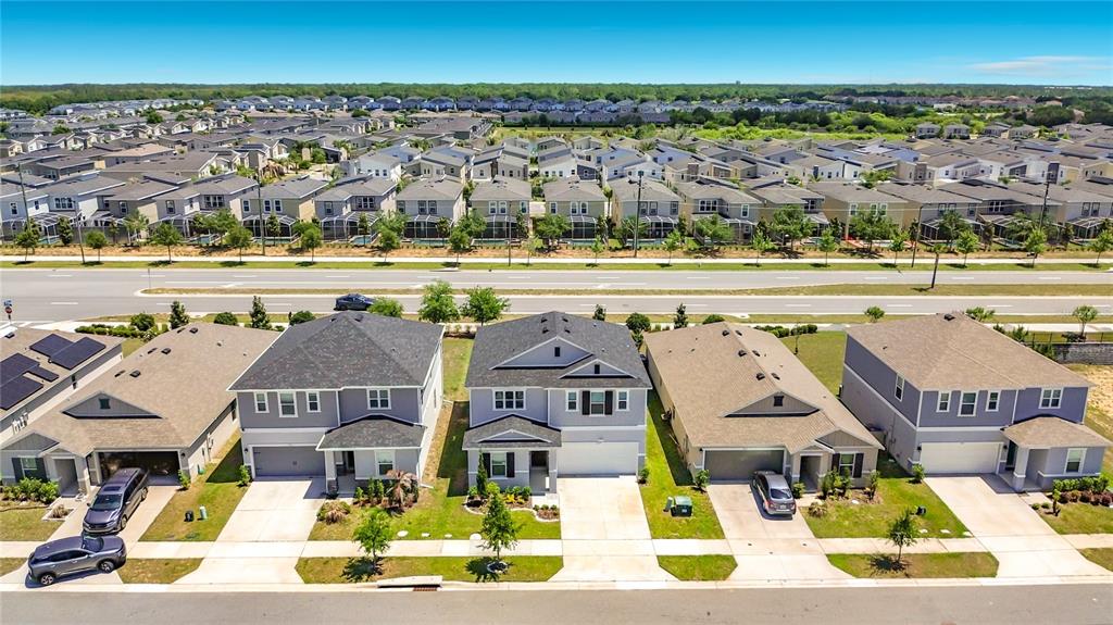 An aerial view shows a row of suburban houses with driveways facing a paved road — 795 OVERPOOL AVENUE, DAVENPORT, FL