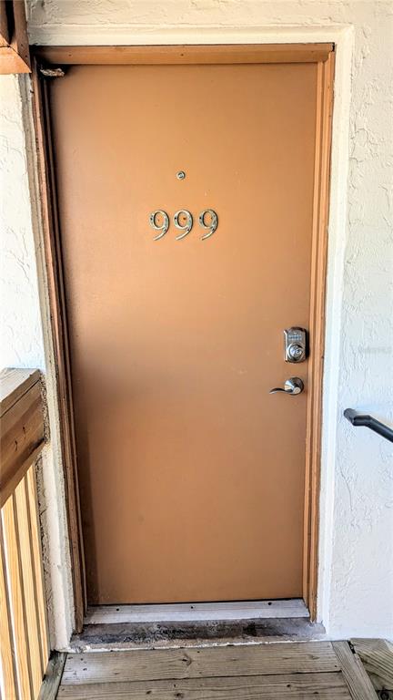A brown exterior door with the number 999 and a keypad lock on a wooden deck — 6327 MIDNIGHT PASS RD ROAD UNIT 999, SARASOTA, FL