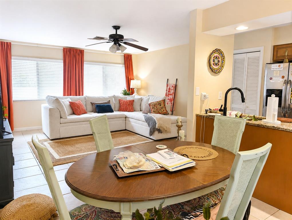 A dining area with a wooden table and chairs opens into a living room — 6327 MIDNIGHT PASS RD ROAD UNIT 999, SARASOTA, FL
