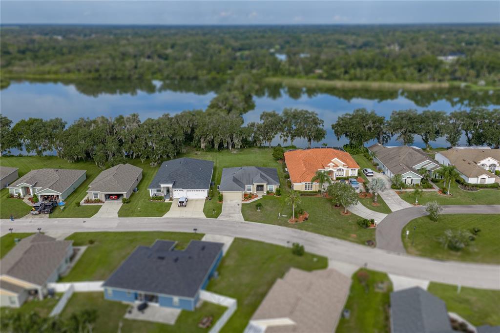 An aerial view of a suburban neighborhood with houses situated along a lakefront — 4505 FAIRWAY OAKS DRIVE, MULBERRY, FL