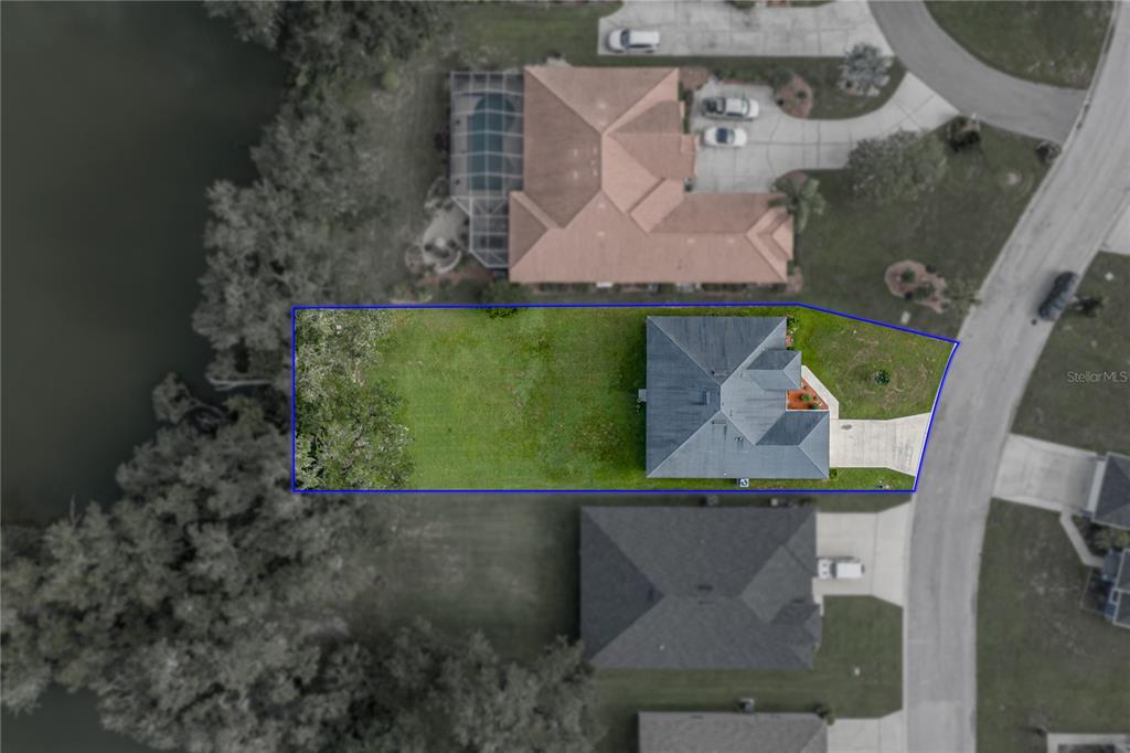 An aerial view shows a house with a large backyard bordering a wooded area — 4505 FAIRWAY OAKS DRIVE, MULBERRY, FL