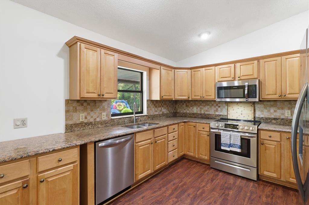 A kitchen with light wood cabinets, granite countertops, stainless steel appliances, and wood-look flooring — 9685 W TOM MASON DRIVE, CRYSTAL RIVER, FL