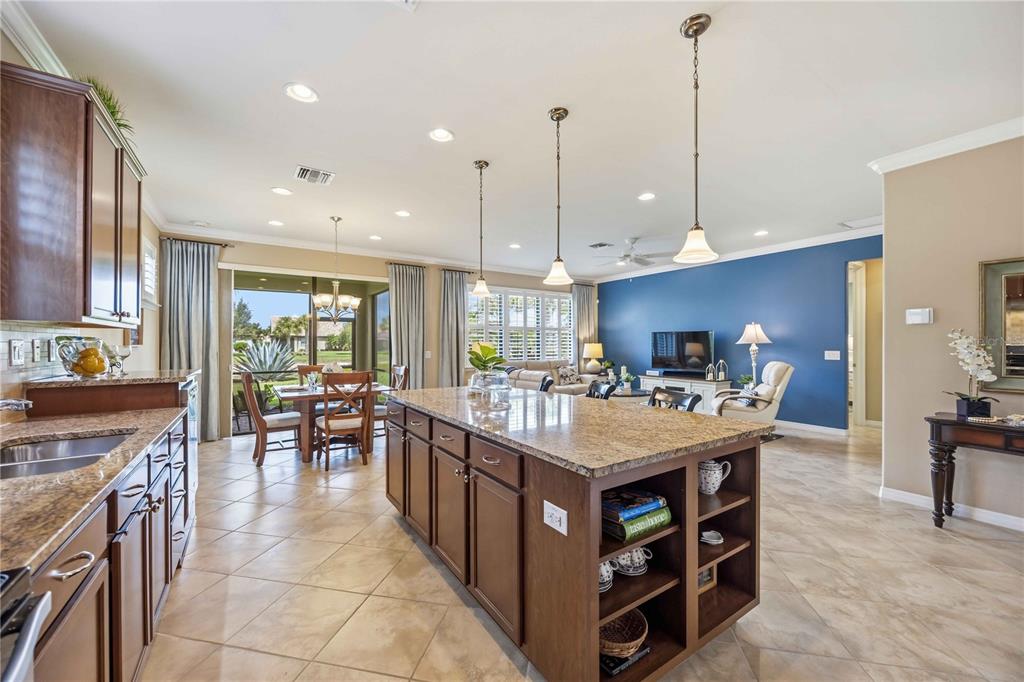 A living room features a blue accent wall, white furniture, and tile flooring — 19731 QUISTO STREET, VENICE, FL