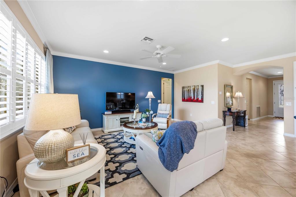 A living room features a blue accent wall, white furniture, and tile flooring — 19731 QUISTO STREET, VENICE, FL