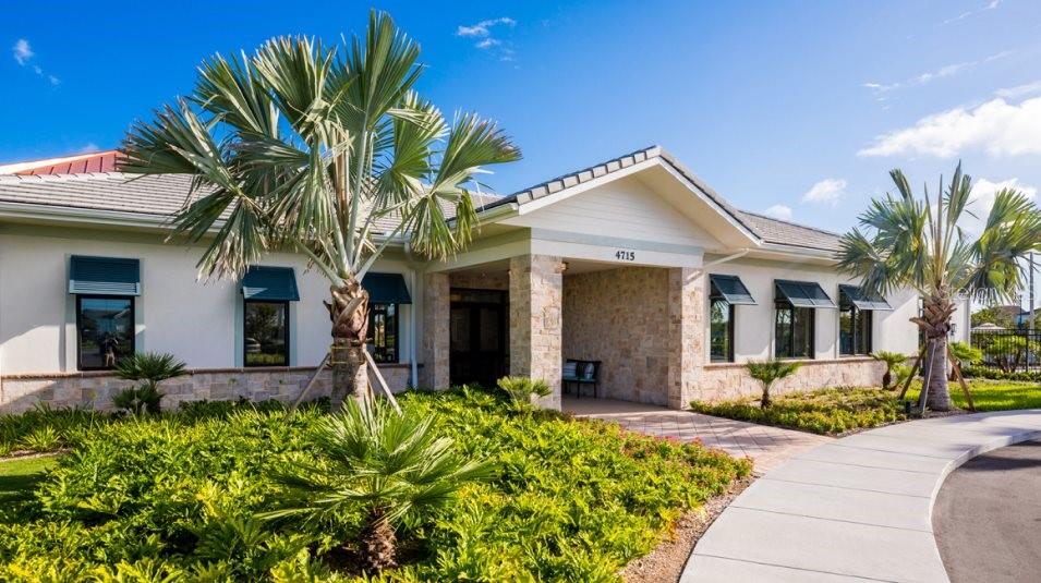A single-story building with a stone-accented entrance, palm trees, and a paved walkway — 3873 AMERS LOOP, HAINES CITY, FL