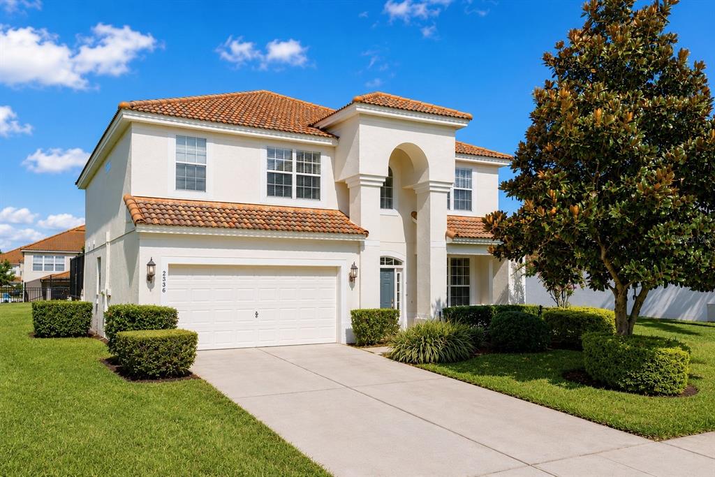 A two-story stucco house with a tile roof and a two-car garage — 2536 HOLTROCK STREET, KISSIMMEE, FL