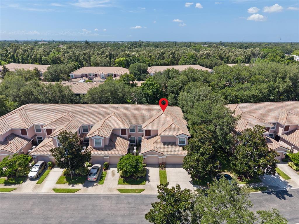 An aerial view shows a multi-unit townhouse complex with tile roofs and paved driveways — 2061 CARRIAGE LANE UNIT 104, CLEARWATER, FL