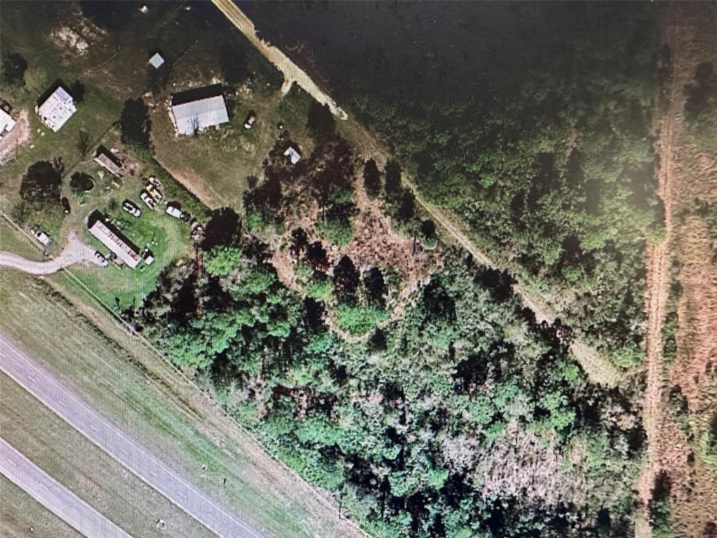 An aerial view shows a rural property with a house, outbuildings, trees, and a highway — E STATE ROAD 60, OKEECHOBEE, FL