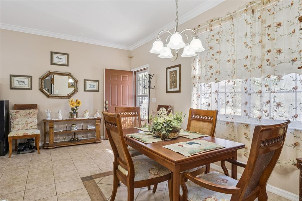 A dining room with a wooden table, chairs, tile flooring, and a chandelier — 9200 E WINDWOOD LOOP, INVERNESS, FL