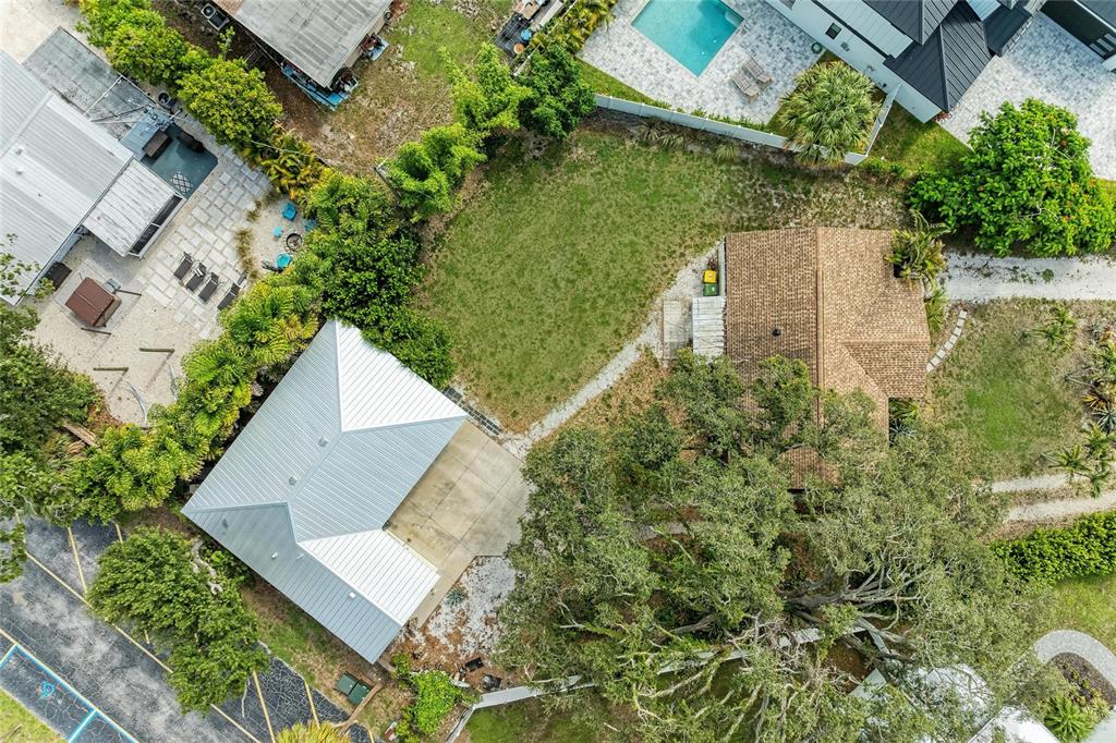A gravel driveway leads to a single-story house with palm trees and landscaping in front — 1300 LOMA LINDA COURT, SARASOTA, FL