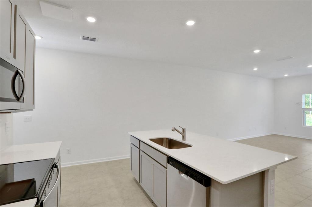 A kitchen with a white island, stainless steel appliances, and light-colored cabinetry — 3727 ATHENIAN WAY, MIDDLEBURG, FL