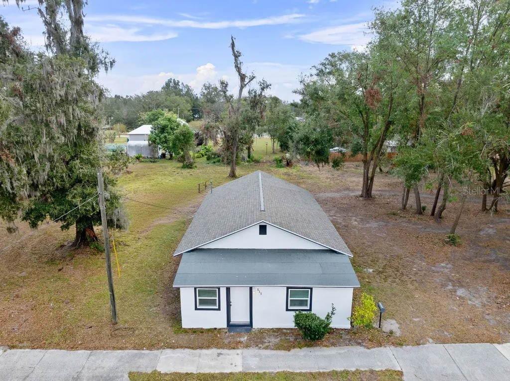 An aerial view shows a small white house with a gray roof and a large yard — 515 S CHARLESTON AVENUE, FORT MEADE, FL