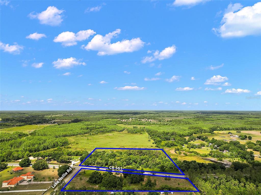 An aerial view shows a wooded, rectangular plot of land bordered by two roads — 7845 COUNTY ROAD 561, CLERMONT, FL