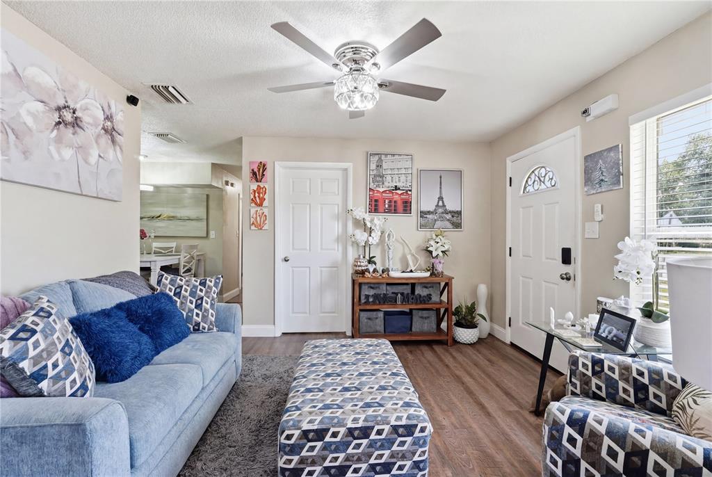 A dining area with a white table and chairs sits adjacent to a white kitchen — 1410 KOZART COURT, ORLANDO, FL