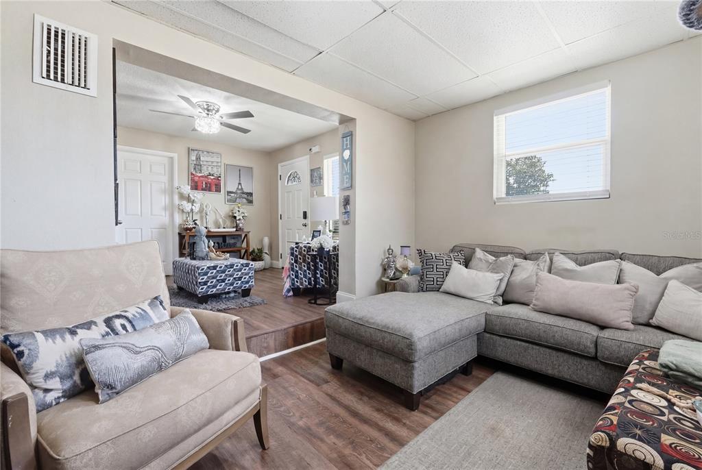 A galley kitchen features white cabinets, granite countertops, stainless steel appliances, and a dining area — 1410 KOZART COURT, ORLANDO, FL
