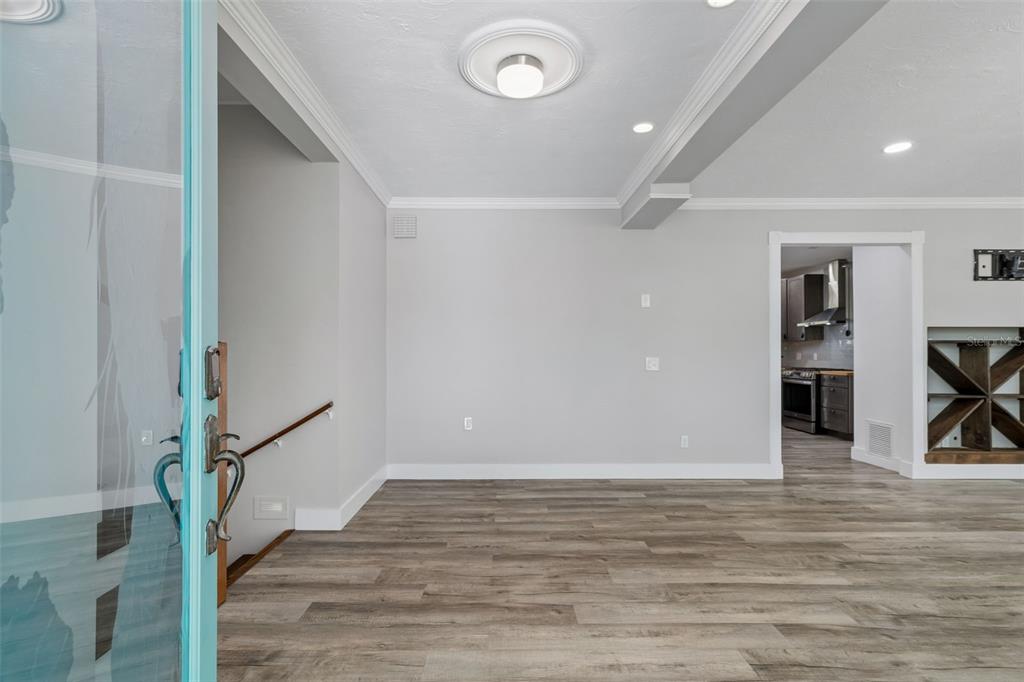 A view from a doorway into a room with gray walls and wood-look flooring — 904 BAYSHORE DRIVE, TARPON SPRINGS, FL