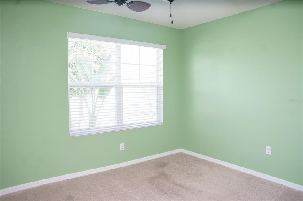 An empty bedroom features light green walls, beige carpeting, and a window with white blinds — 2614 GREENLEAF TERRACE, PARRISH, FL